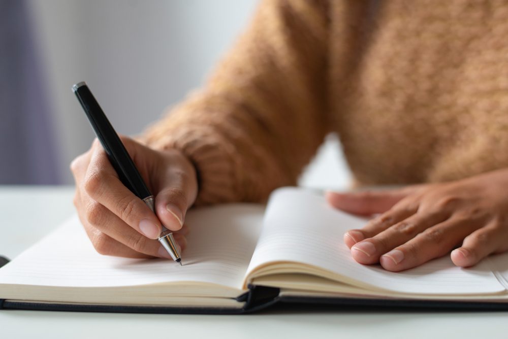 person writing in a journal