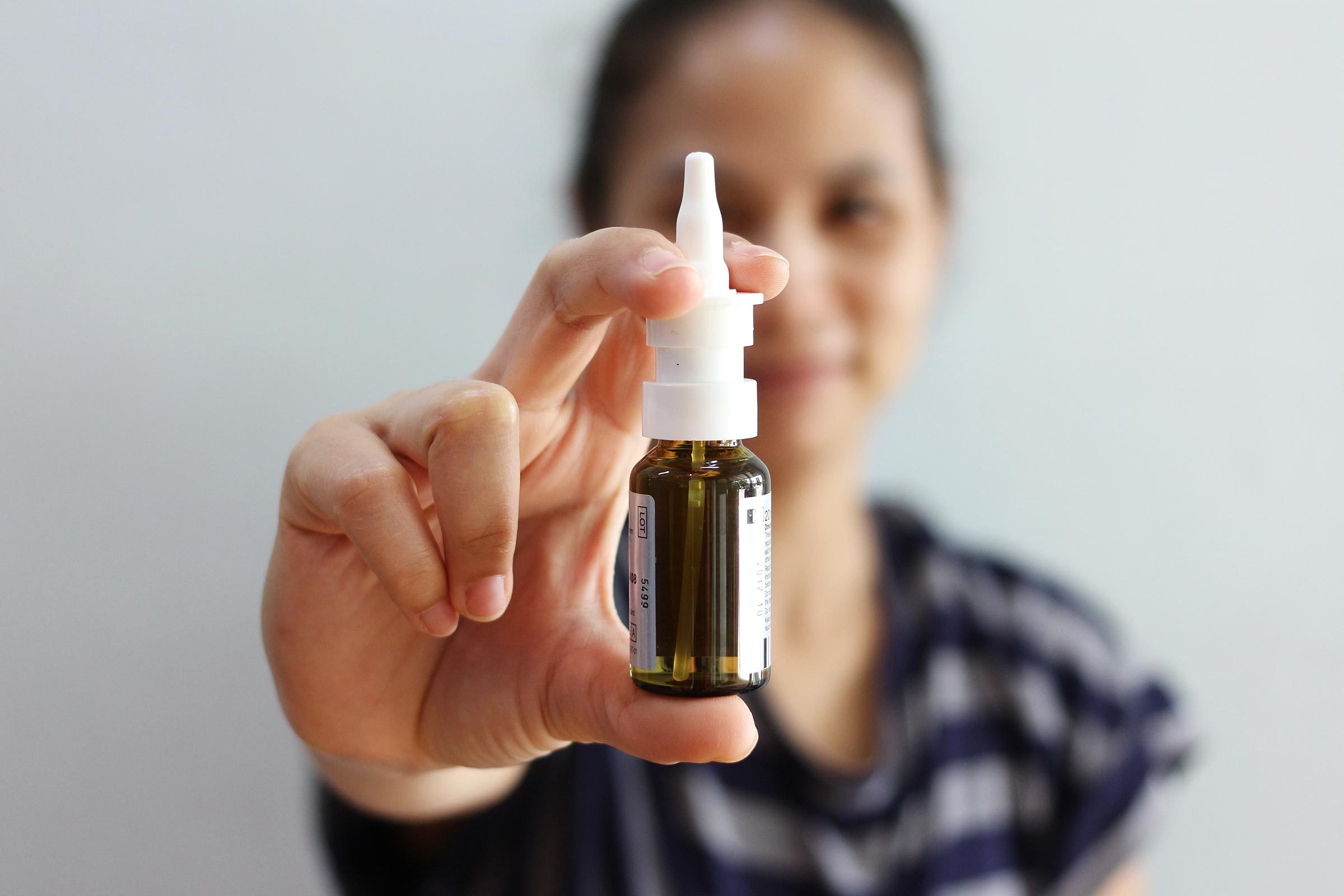 woman holding nasal spray