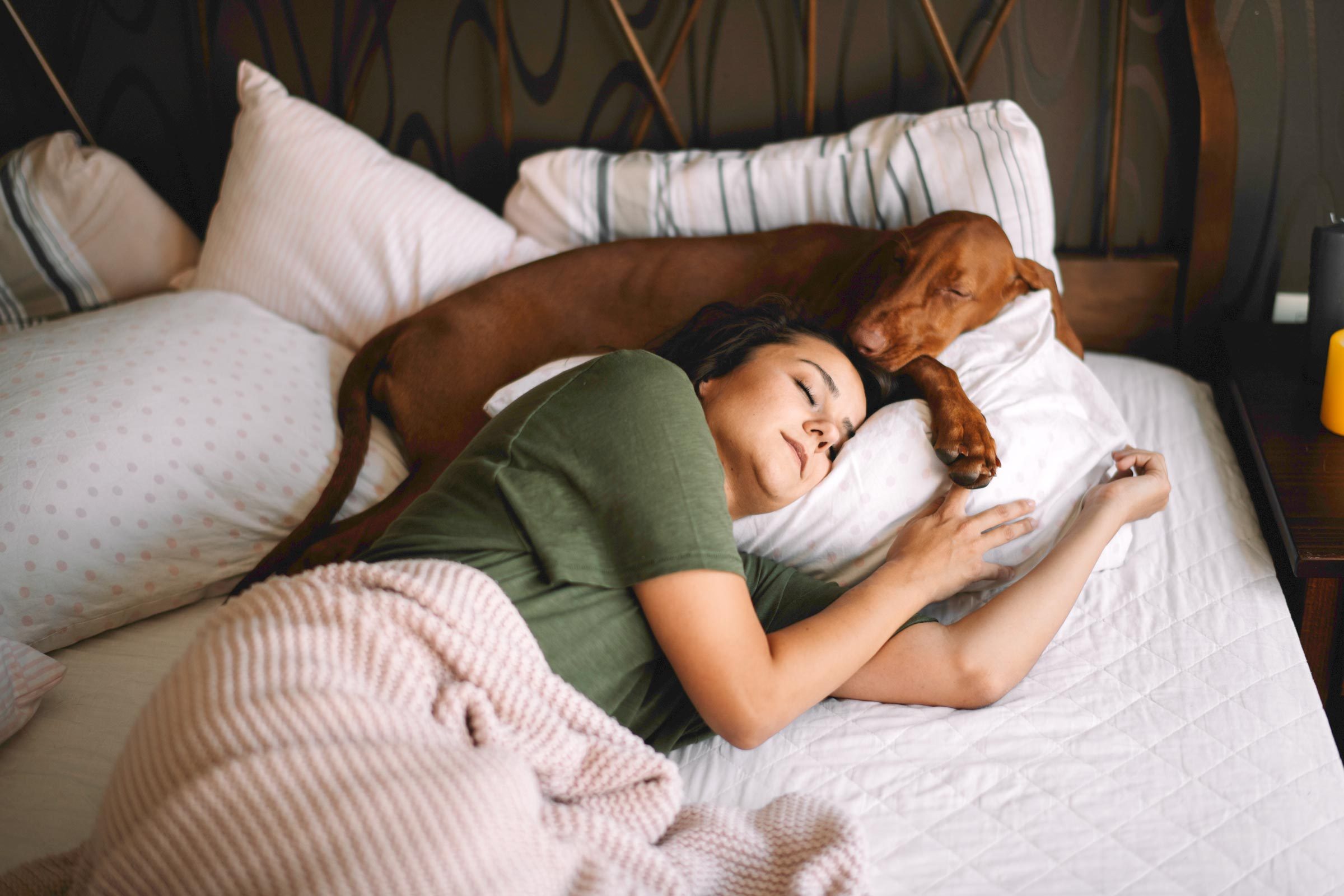 woman sleeping with her dog