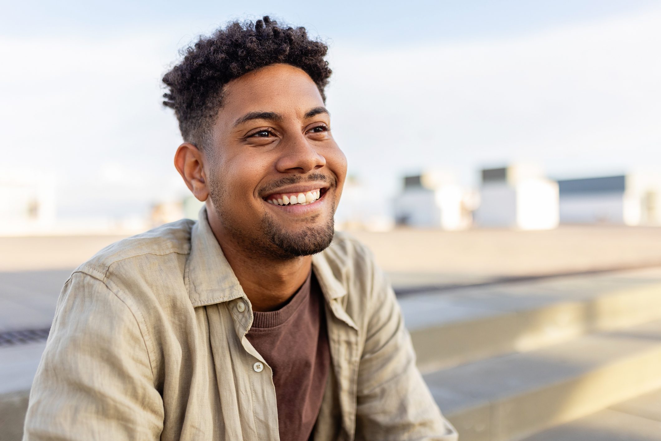 Portrait of young smiling african american man sitting outdoors.