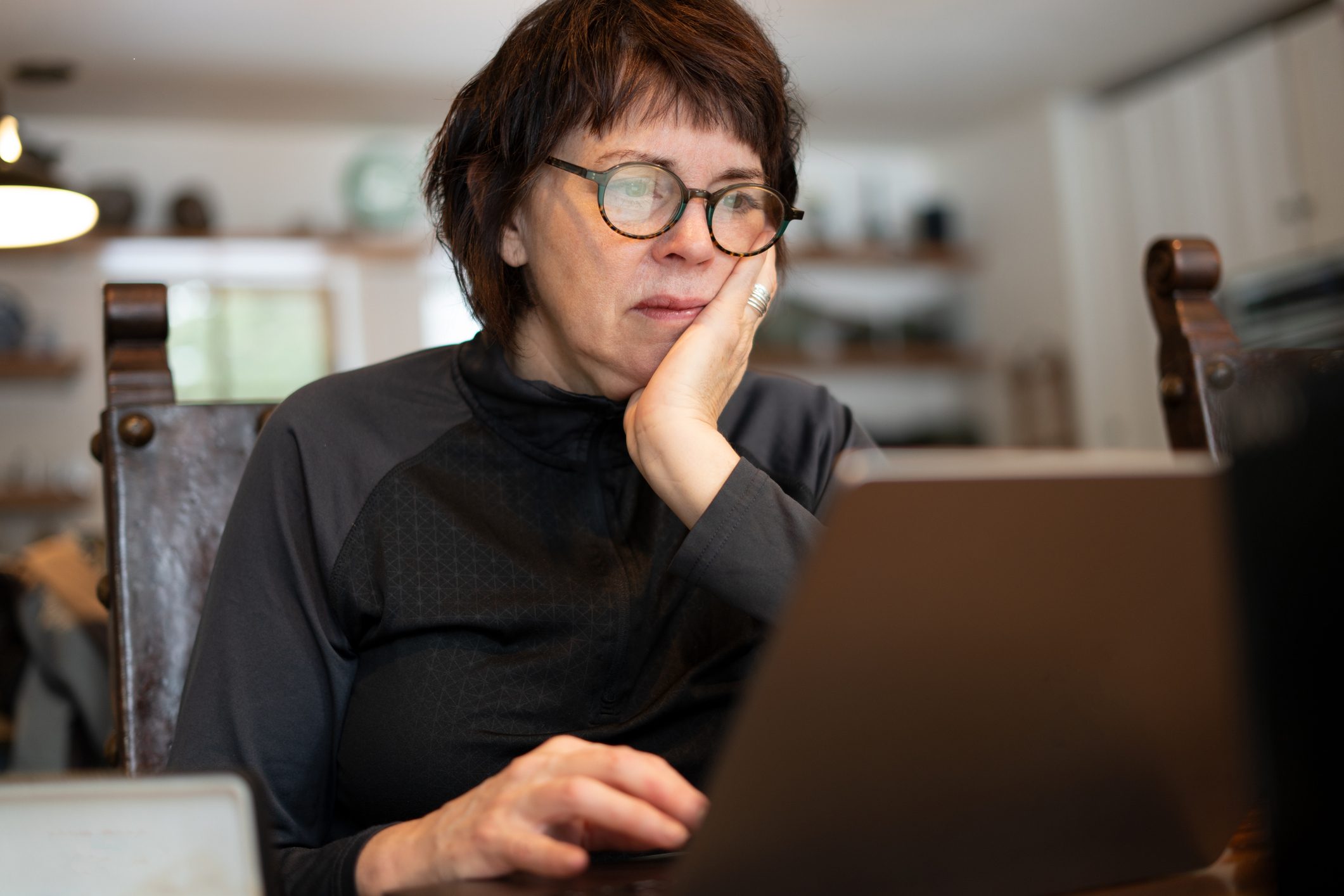 Woman working on computer at home and confused