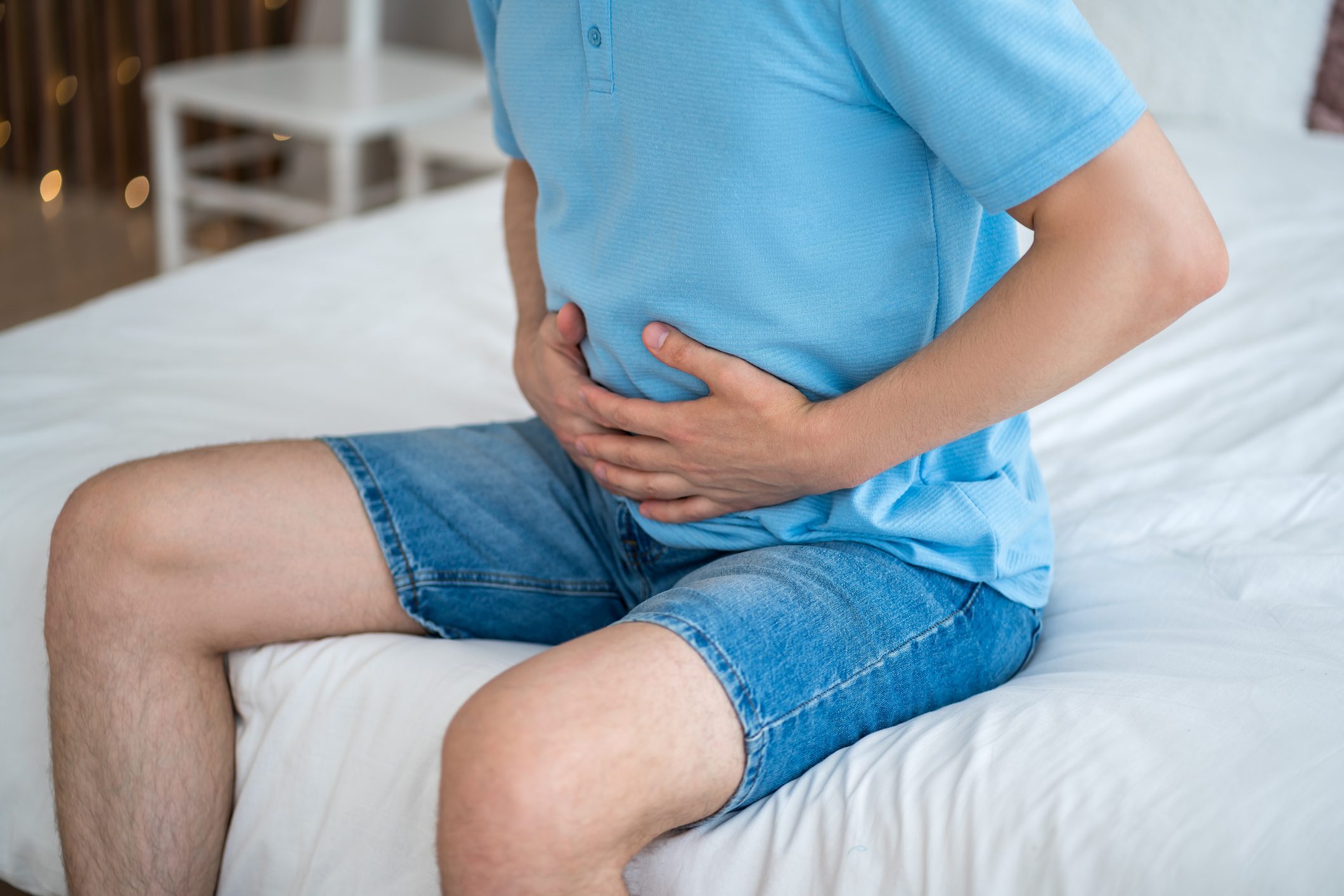 Stomach ulcer, bloating, man with abdominal pain suffering at home, symptoms of gastritis, diseases of the digestive system
