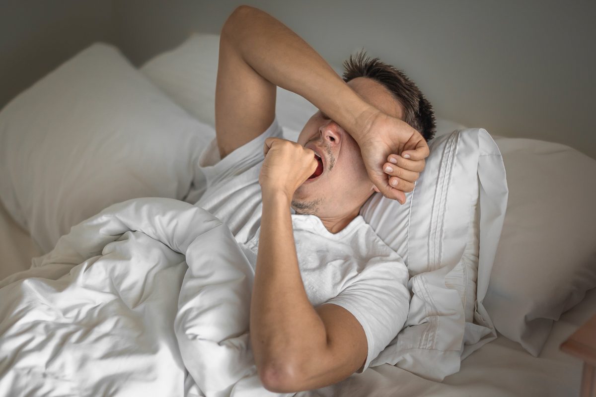 man waking up tired